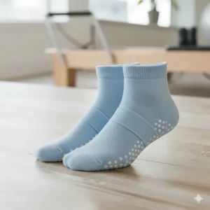 A pair of cute ankle-strap style pilates or barre socks in a light blue color.