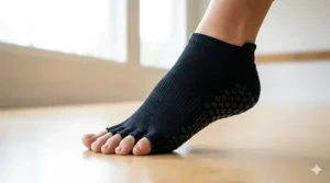 A pair of black open-toe barre socks providing toe splay and breathability during a workout.